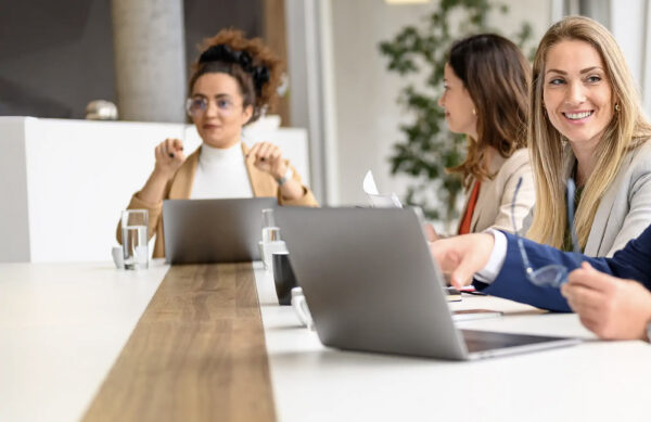 Twee collega's die samen achter een laptop werken op kantoor