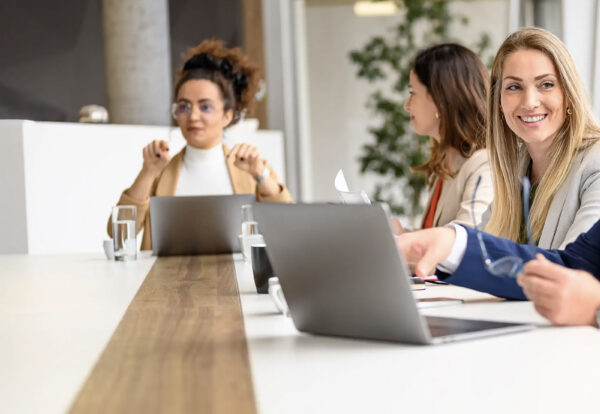 Twee collega's die samen achter een laptop werken op kantoor