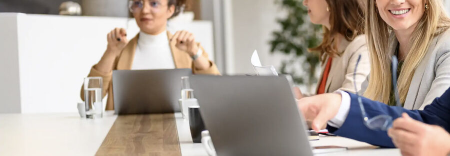 Twee collega's die samen achter een laptop werken op kantoor